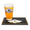 A bar mat with a pint glass full of beer on it.