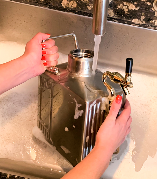 rinsing a Craft Master pressurized growler under warm water after a wash.