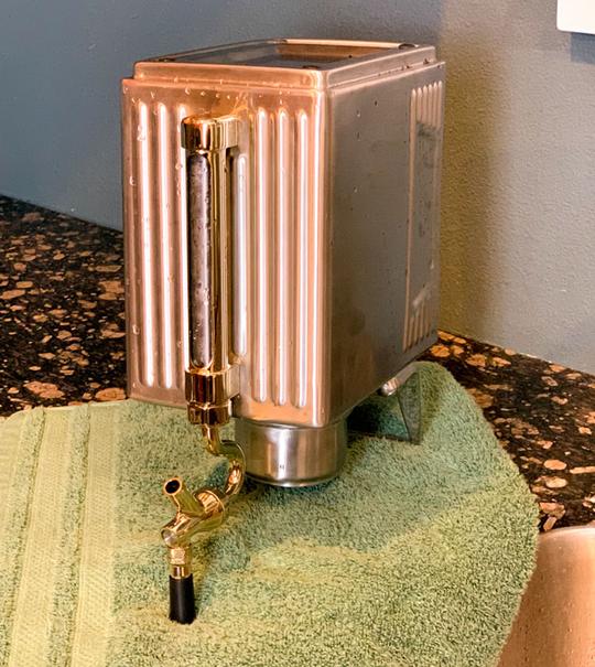 A pressurized growler sitting upside down on a towel for drying.