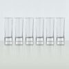 six 4oz shot glasses lined up on a white background.