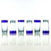 alternating right side up and upside down 3.75oz shooter shot glasses with blue rims.
