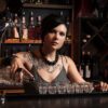 bartender pouring into shot glasses at a pub.