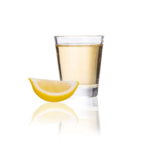 a 1.75oz shot of tequila with a lemon on a reflective white background.