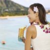 woman enjoying a beverage from her 16oz blue and orange tiki glass by the beach.