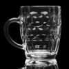 19oz German style, dimpled, Oktoberfest mug with handle on a black background and backlit.