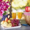 two stange glasses on a table setting with grabes, cheese, and crackers.