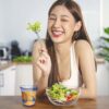 asian woman having a healthy drink from a hand blown 10oz rocks glass made from swirly blue and white glass.