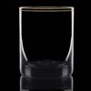 backlit gold rimmed whisky glass on a black background.