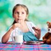 young girl drinking milk from a 22oz glass mug.