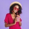 woman drinking a smoothie out of a faceted double old fashioned glass.