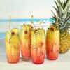 set of 4 20 ounce tiki highball glasses with fruity beverages and a pineapple.