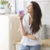 woman drinking purple juice from a 12.5oz handblown hi-ball glass with a cobalt blue swirl.